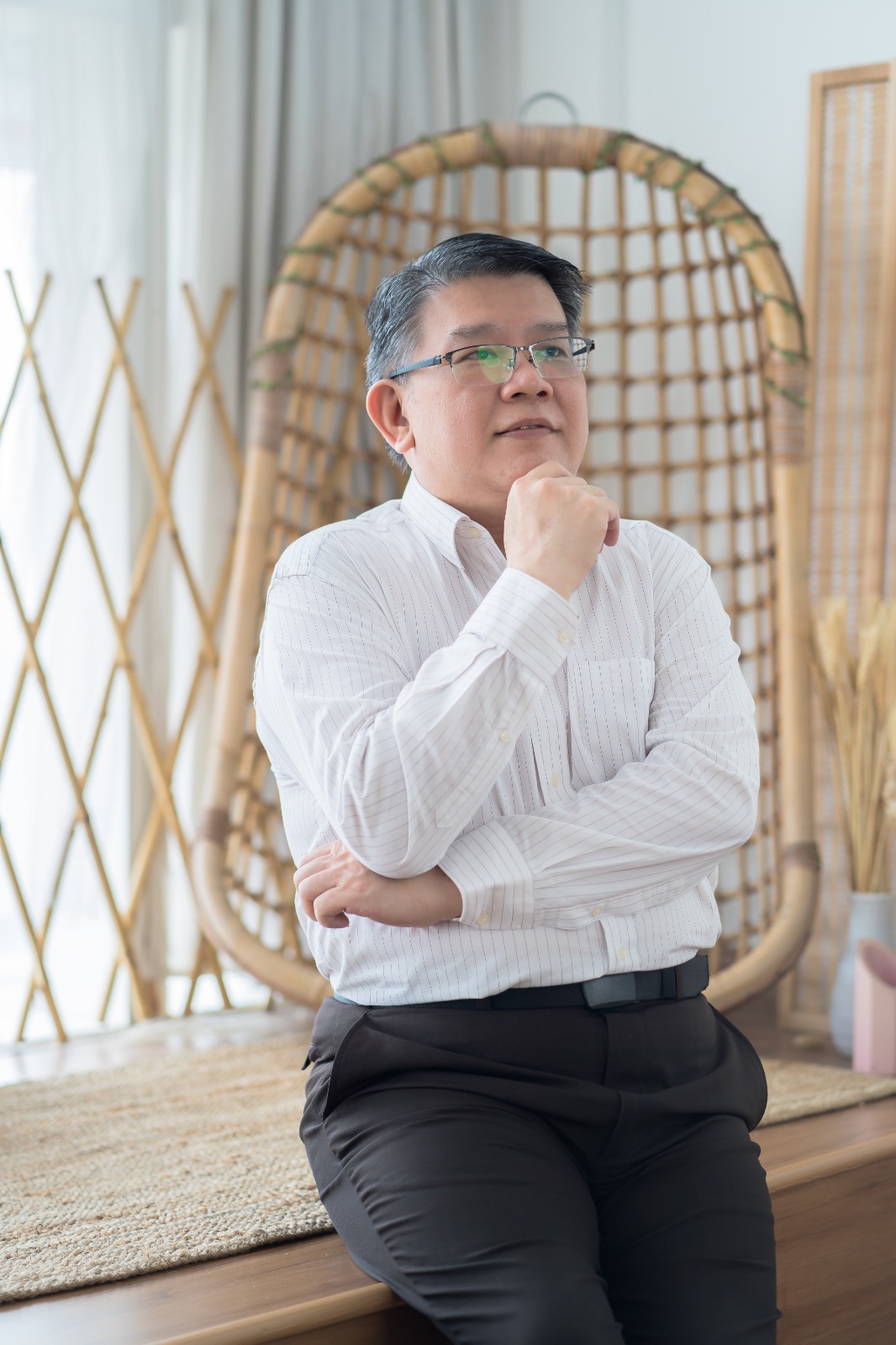 Kelvin Ng Choo Kent seated thoughtfully in a bright training environment